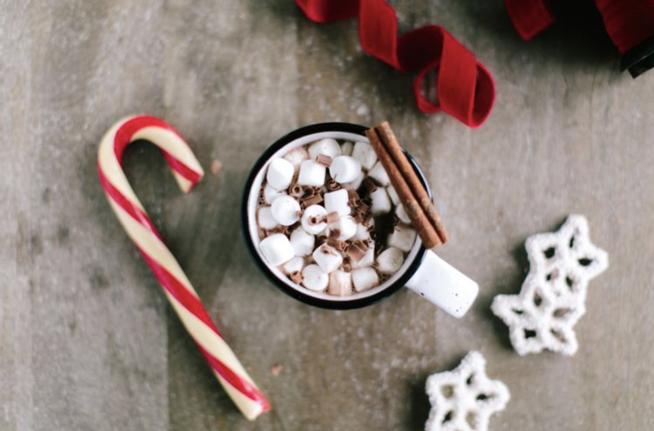 A cozy cup of hot chocolate with fluffy marshmallows, candy canes, and snowflake cookies, perfect for the holidays.
